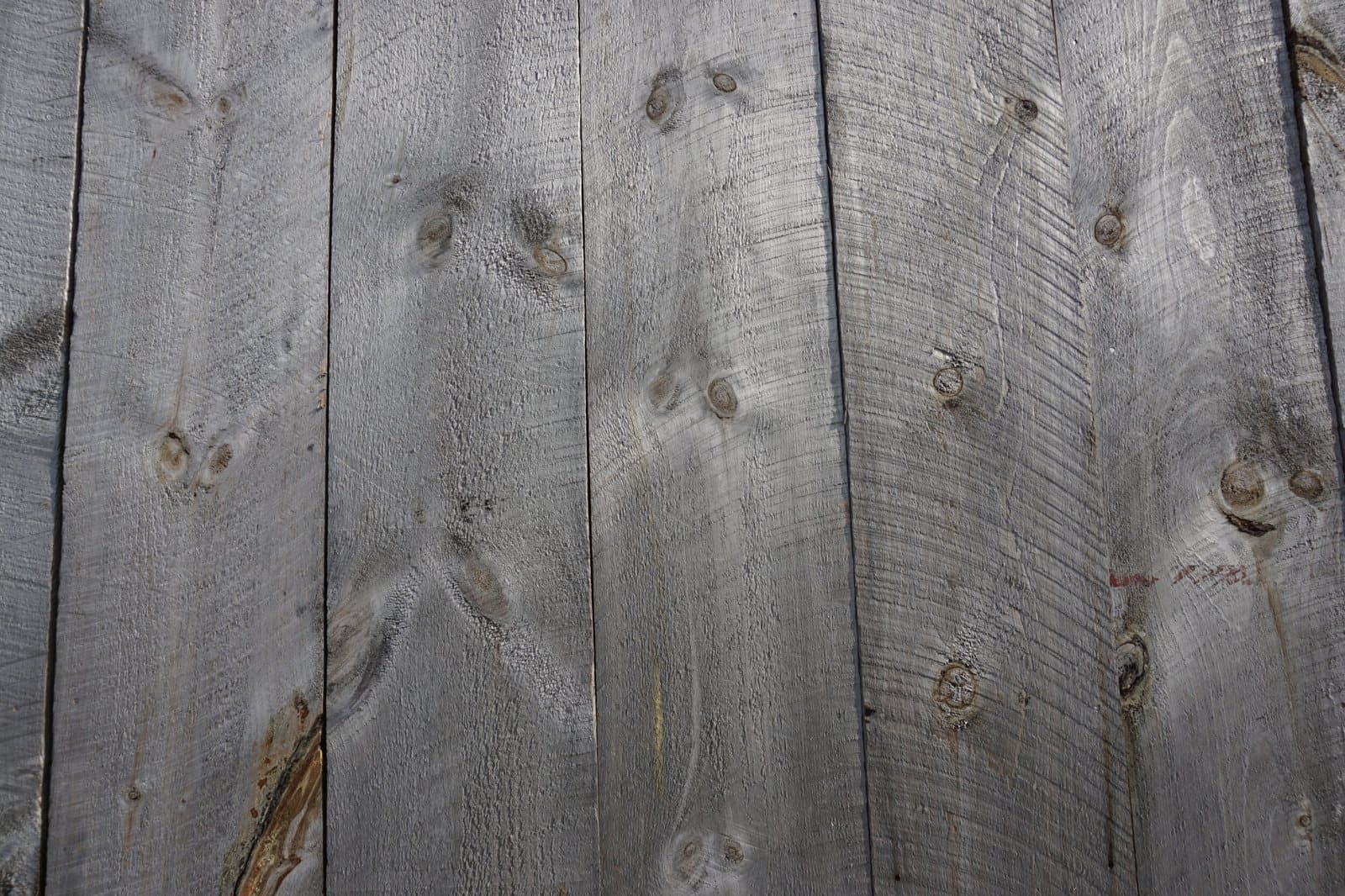 Reclaimed gray barn board showing knots and weathered grain
